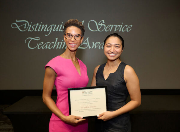 Makeba Williams accepts the Humanism in Medicine award from Isabella Gomes.