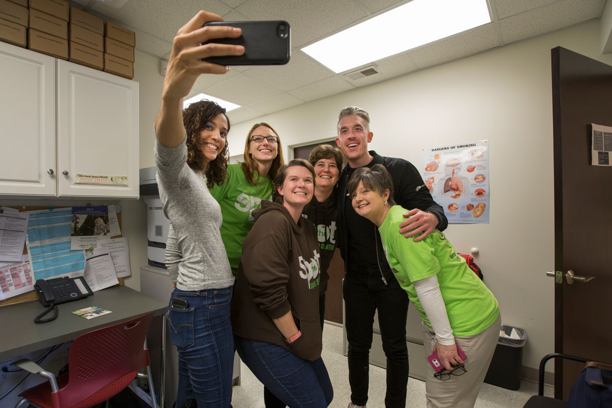 (From left) Shadille Estepan of the Born This Way Foundation; Denise Willers, MD; case manager Liz Neuf; Katie Plax, MD; Alex Aide of the foundation; and Kim Donica, executive director of The SPOT, smile for a group shot at the youth center.