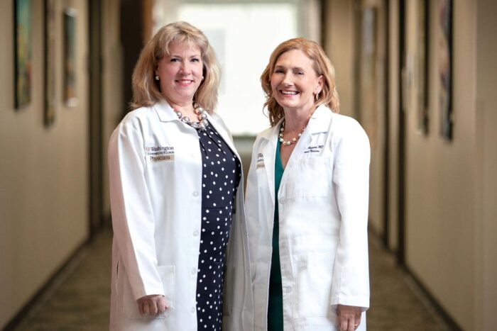 Valerie Ratts and Eva Aagaard wearing white coats and smiling into camera