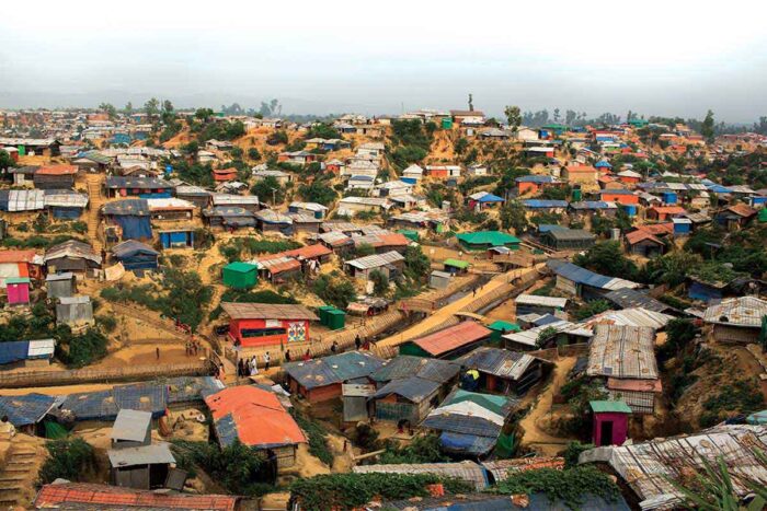 Hundreds of colorful huts cover muddy hillsides at Rohingya camp on the Bangladesh-Myanmar border.
