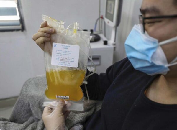 In this Feb. 18, 2020, file photo, Dr. Zhou Min, a recovered COVID-19 patient who has passed his 14-day quarantine, donates plasma in the city's blood center in Wuhan in central China's Hubei province. Plasma from recovered COVID-19 patients contains antibodies that may help reduce the viral load in patients that are fighting the disease.