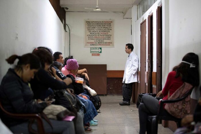 Angel Velarde, MD, research director at the Instituto Nacional de Cáncerologia (INCAN), stops in a hallway to speak with patients waiting for radiation therapy. Patients are treated on a first-come, first-served basis and waiting rooms quickly fill up.