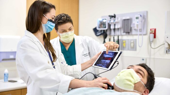 Hospitalists Crystal Atwood, MD (left), and Stephanie Conner, MD, use POCUS (point-of-care ultrasound).