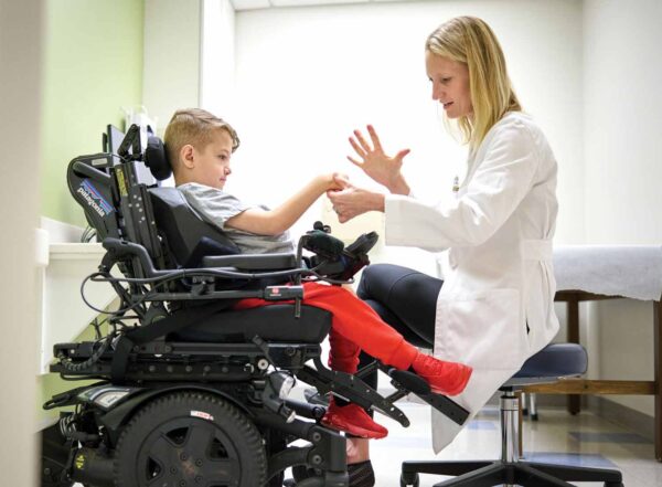 Alumna Lindley Wall, MD, examines the arms, wrists and hands of Alexander Trudo, 9, at St. Louis Children’s Hospital.